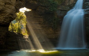 Rays of the sun and the water fall into the cave