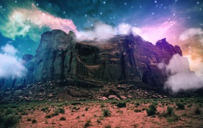 Скала в тумане на фоне звезд