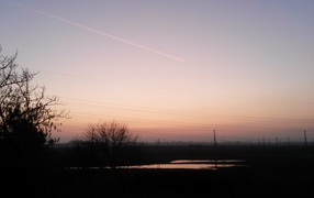 След самолета на розовом небе