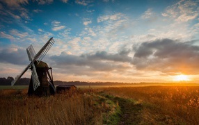 Мельница среди поля на фоне заката