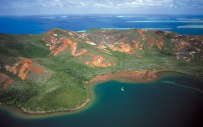 Белая лодка у необитаемого лесистого острова