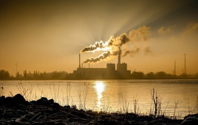 Лучи солнца пронизывают дым из заводских труб