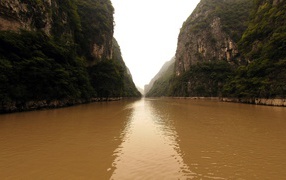 Коричневая вода реки между скал