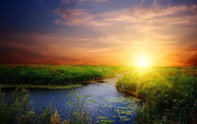 Река среди зеленой травы на закате