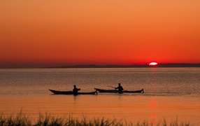 Два лодочника на фоне заката