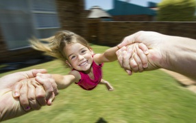 Веселая девочка в руках отца