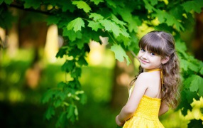 Маленькая девочка у зеленого клена