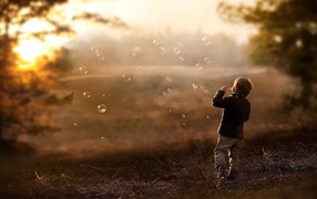 Мальчик запускает мыльные пузыри