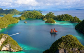 Корабль с красными парусами среди островов