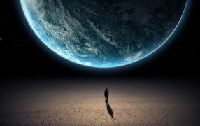 Человек стоит перед планетой