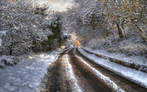 Черная колея на зимней дороге