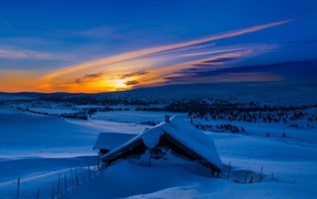 Занесенная снегом избушка