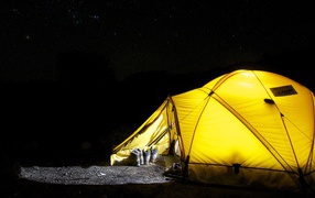 Желтая палатка туристов под ночным небом