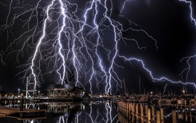 Молнии в черном небе над портом