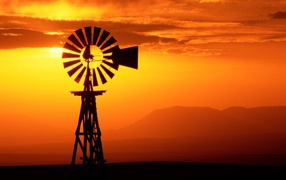 Ветряк флюгер на фоне заката, США