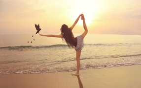 Ballerina on the beach with bird