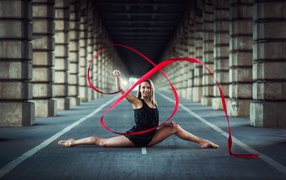 Gymnast exercising with a red ribbon