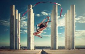 Gymnast with a ribbon on a background of columns