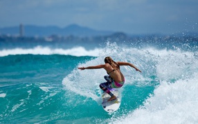 Surfer girl straddled the blue wave