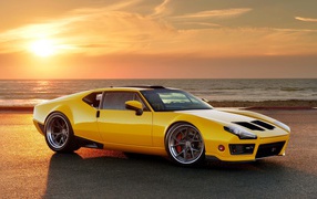 Желтый спортивный автомобиль De Tomaso Pantera на фоне заката