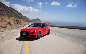 Красный автомобиль  Audi RS 3 на трассе на фоне голубого неба