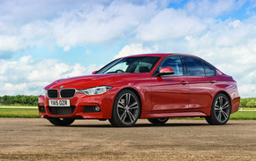 Stylish red BMW 3 Series car on a sky background