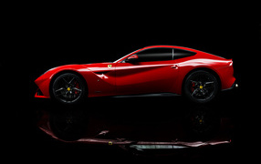 Красный спортивный автомобиль Ferrari F12 berlinetta на черном фоне