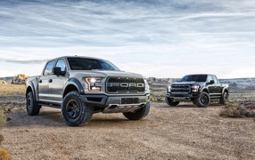Two stylish pickups Ford F-150 Raptor, 2017 under the beautiful sky