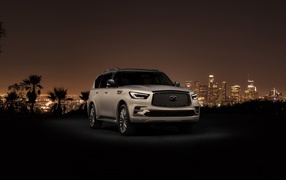 Автомобиль Infiniti QX80 2018 на фоне ночного города