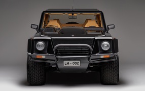 Черный автомобиль Lamborghini LM002 на сером фоне
