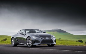 Серебристый автомобиль Lexus LC 500h, 2018 под грозовым небом