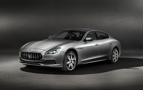 Серебристый автомобиль Maserati Ghibli GranLusso на сером фоне