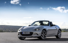 Серебристый кабриолет Mazda MX-5 на фоне красивого неба