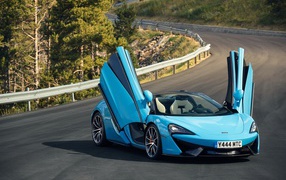 Синий спортивный автомобиль McLaren 570S на трассе с открытыми дверями