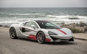 Спортивный автомобиль McLaren 570S на фоне океана