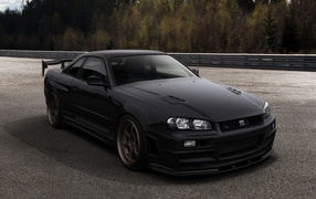 Черный автомобиль Nissan Skyline GT-R R34 на трассе