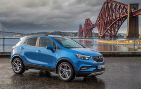 Синий автомобиль Opel Mokka у моста 