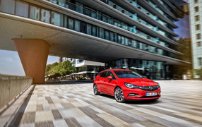 Красный автомобиль Opel Astra в движении