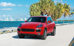 Red SUV Porsche Cayenne on the background of the ocean