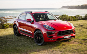 Red car Porsche Macan, 2017 on the background of the ocean
