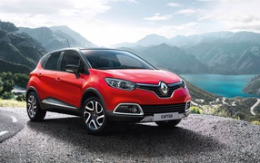 Красный автомобиль внедорожник Renault Captur на фоне гор