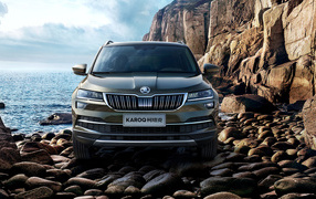 Внедорожник Skoda Karoq на камнях у скалы на фоне океана