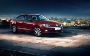 Красный автомобиль Volkswagen Jetta на фоне ночного города