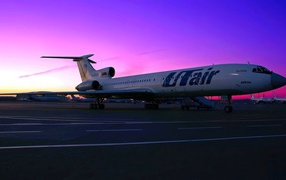 Пассажирский самолет Ту-154 российской авиакомпании UTair на фоне заката 