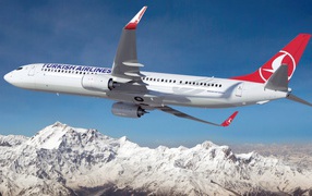 Boeing 737 - 900ER авиакомпании Turkish Airlines пролетает над заснеженными горами