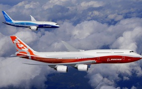 Два пассажирских самолета Боинг 747 в небе бело-синий и бело-красный