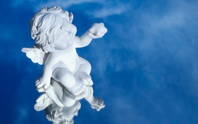 Маленькая статуя купидона отражается в голубой поверхности