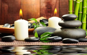 Черные камни дзен с двумя горящими свечами