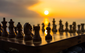 Шахматная доска с шахматными фигурами на закате солнца