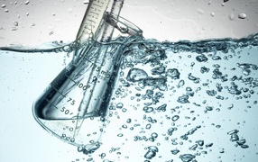 Измерительная чашка в воде с пузырями 